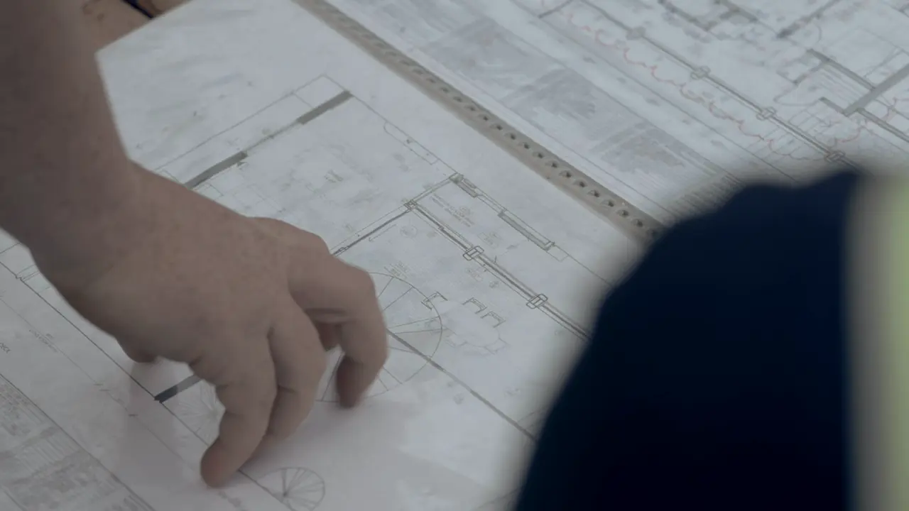 Hands reviewing construction plans on site